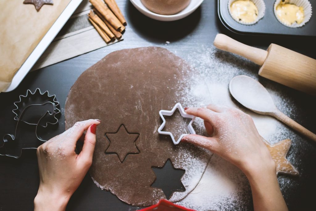 A woman cutting out a star on a dough