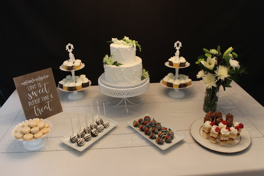 Table full of desserts and a white wedding cake
