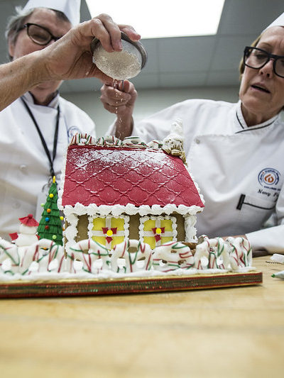 Two chefs decorating a cake